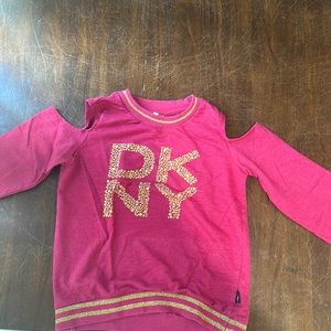 It’s a DKNY pink long sleeve shirt that’s a name brand size 12 Y